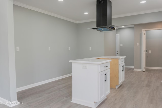 kitchen with crown molding, baseboards, and island range hood