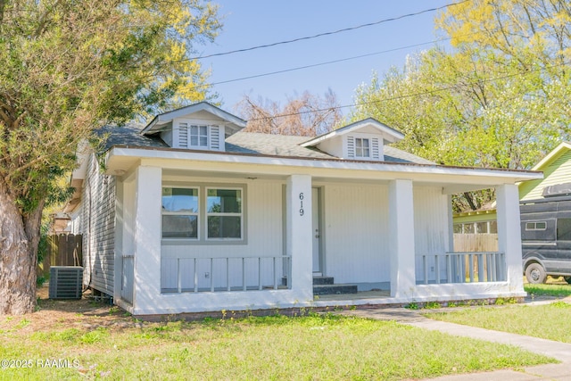 bungalow-style house featuring central air condition unit, a porch, and a front lawn