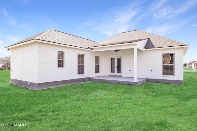 back of property featuring a lawn, a ceiling fan, french doors, brick siding, and a patio area