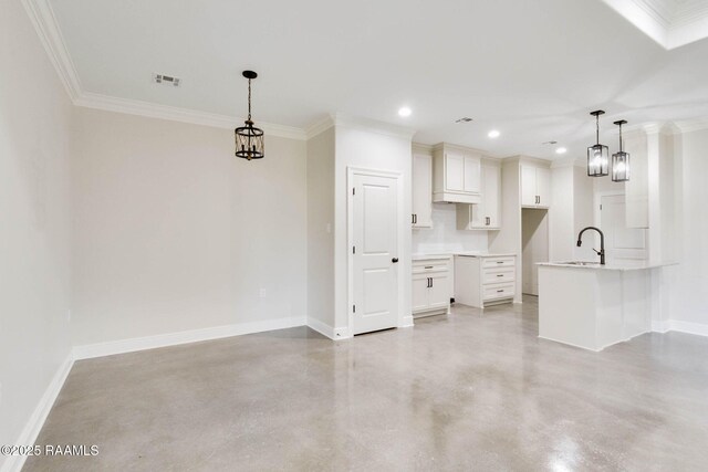 kitchen featuring a peninsula, concrete floors, baseboards, and a sink