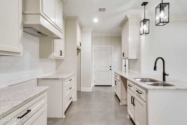 kitchen with a sink, light stone counters, tasteful backsplash, and ornamental molding