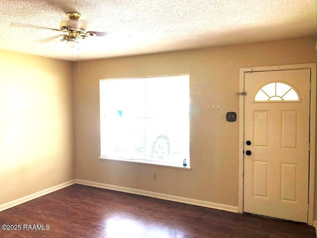 entrance foyer featuring baseboards, a textured ceiling, dark wood finished floors, and a ceiling fan