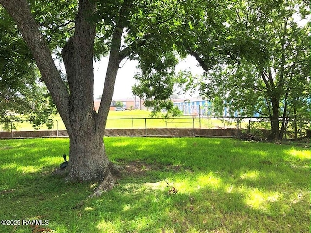 view of home's community featuring a yard and fence