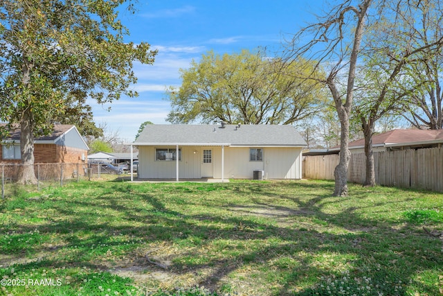 back of property featuring a yard, a fenced backyard, and cooling unit