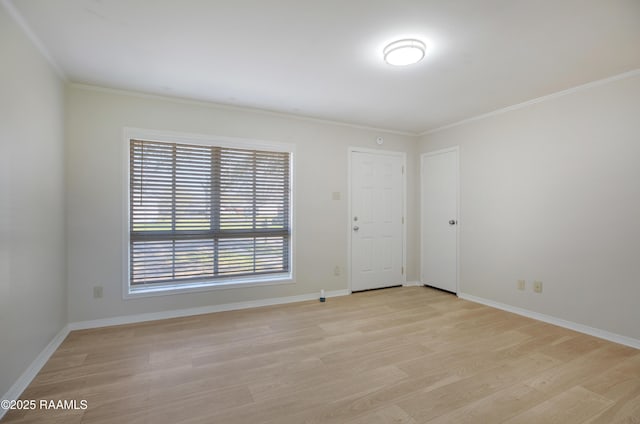 unfurnished room with baseboards, crown molding, and light wood-style floors