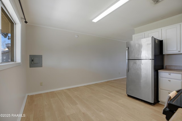 kitchen with white cabinetry, light wood-style floors, freestanding refrigerator, and black range oven