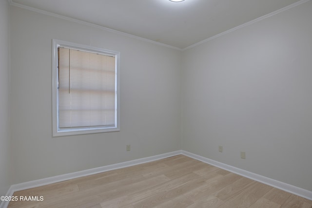 empty room with crown molding, baseboards, and light wood-type flooring