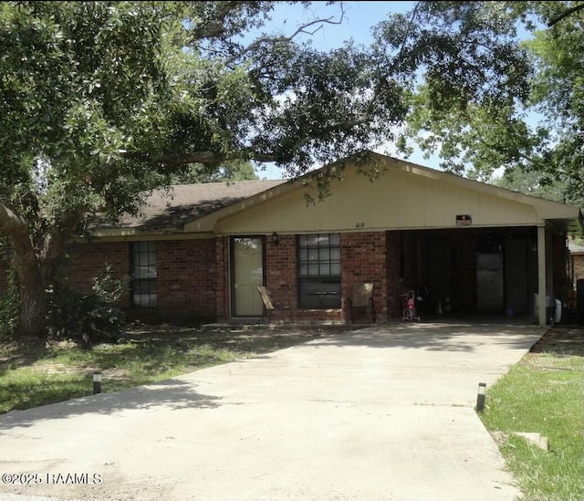 view of front of home with a garage, brick siding, and driveway