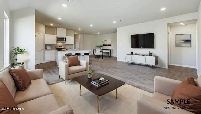 living room featuring recessed lighting, baseboards, and light wood finished floors