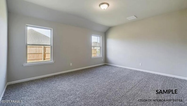 carpeted spare room with visible vents, baseboards, and vaulted ceiling