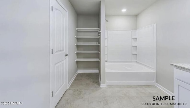 full bath with vanity, baseboards, and a closet