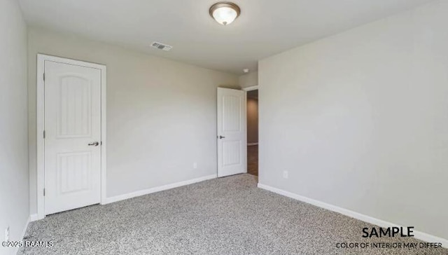 carpeted empty room with visible vents and baseboards