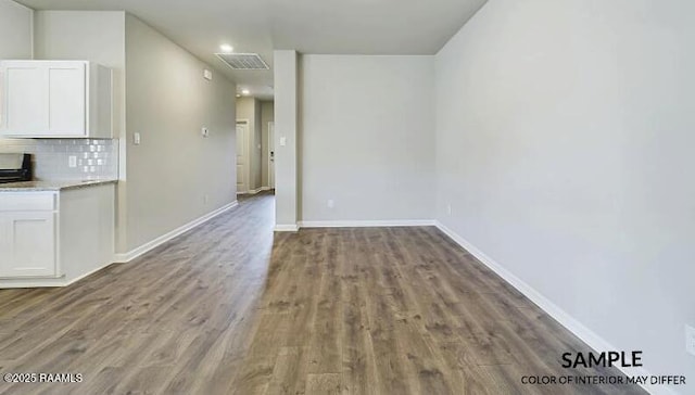 interior space featuring visible vents, wood finished floors, and baseboards