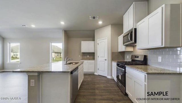 kitchen with visible vents, backsplash, light stone counters, appliances with stainless steel finishes, and a sink