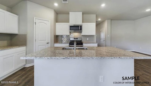 kitchen featuring stainless steel appliances, an island with sink, dark wood finished floors, and white cabinets