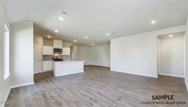 unfurnished living room featuring recessed lighting, visible vents, baseboards, and light wood-style flooring