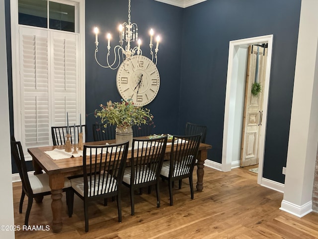 dining space featuring a notable chandelier, wood finished floors, and baseboards