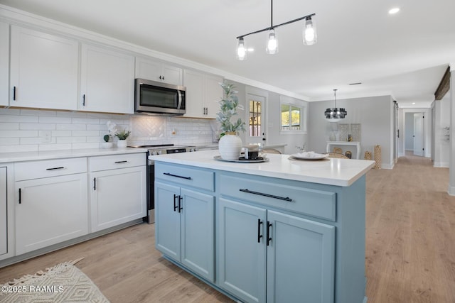 kitchen featuring light wood-style flooring, backsplash, stainless steel appliances, and light countertops