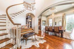 interior space with stairway, wood finished floors, arched walkways, and a chandelier