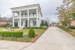 neoclassical / greek revival house featuring a balcony and driveway