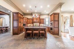 kitchen featuring a kitchen bar, brown cabinets, a center island, a fireplace, and a chandelier