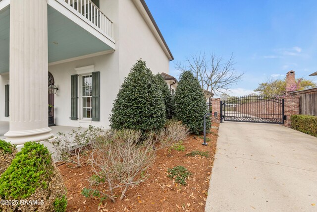 306 Princeton Woods Loop, Lafayette, LA 70508 - view of property exterior with a gate, fence, and stucco siding