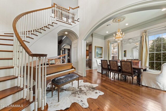 306 Princeton Woods Loop, Lafayette, LA 70508 - entrance foyer with a wealth of natural light, wood-type flooring, a notable chandelier, and arched walkways
