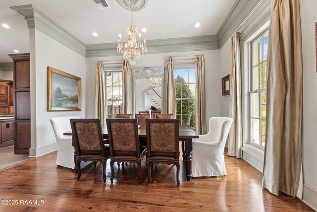 306 Princeton Woods Loop, Lafayette, LA 70508 - dining room featuring plenty of natural light, ornamental molding, an inviting chandelier, and wood finished floors