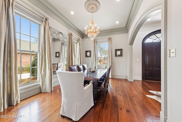 306 Princeton Woods Loop, Lafayette, LA 70508 - dining room featuring an inviting chandelier, arched walkways, wood-type flooring, and ornamental molding