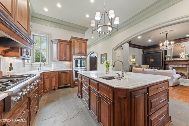 306 Princeton Woods Loop, Lafayette, LA 70508 - kitchen with a sink, open floor plan, stainless steel appliances, arched walkways, and a chandelier