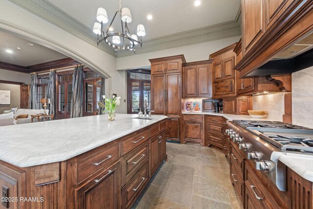 306 Princeton Woods Loop, Lafayette, LA 70508 - kitchen with premium range hood, stainless steel gas cooktop, crown molding, backsplash, and a center island