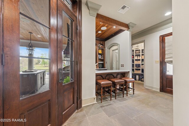 306 Princeton Woods Loop, Lafayette, LA 70508 - foyer featuring wooden ceiling, stone tile floors, visible vents, and ornamental molding
