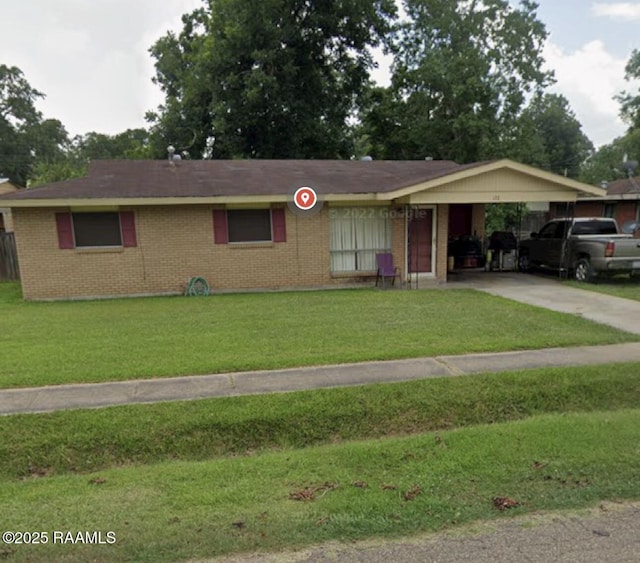 ranch-style house with an attached carport, brick siding, concrete driveway, and a front yard