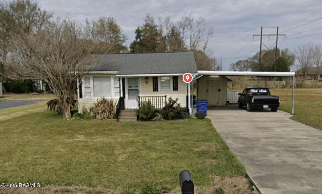 2916 Orangewood Dr, Abbeville, LA 70510 - view of front facade with a carport, concrete driveway, and a front yard