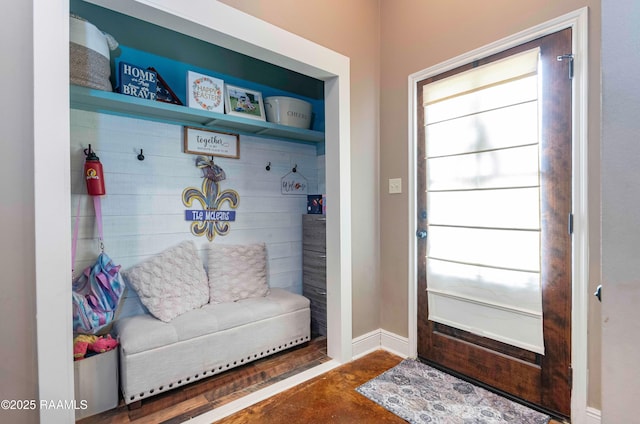 mudroom featuring baseboards and concrete flooring