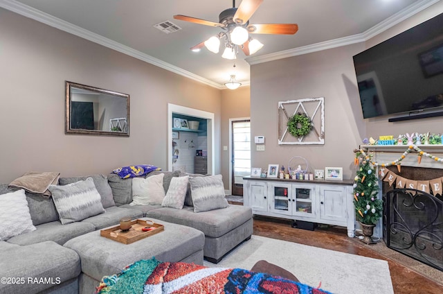 living room featuring visible vents, a ceiling fan, and crown molding