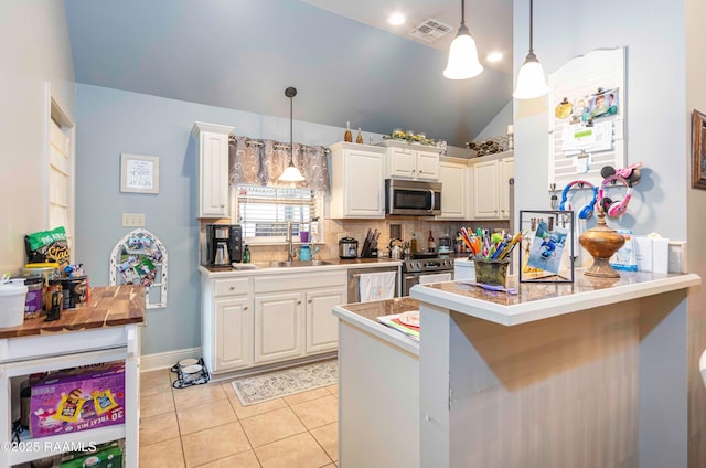 kitchen with visible vents, light tile patterned flooring, appliances with stainless steel finishes, pendant lighting, and white cabinetry