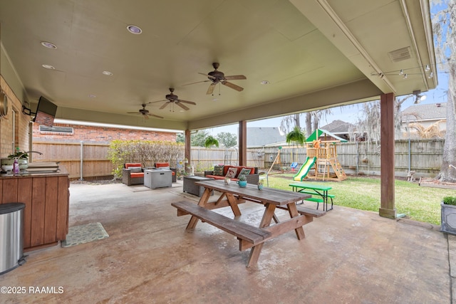 view of patio / terrace featuring a ceiling fan, a playground, a fenced backyard, and visible vents