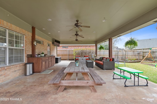 view of patio / terrace with an outdoor living space, a fenced backyard, and a ceiling fan