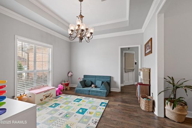 game room with wood finished floors, baseboards, a tray ceiling, ornamental molding, and a notable chandelier