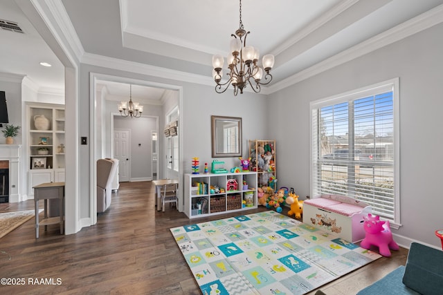 rec room featuring a raised ceiling, a notable chandelier, wood finished floors, and visible vents