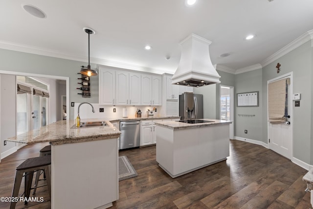 kitchen featuring a sink, island exhaust hood, stainless steel appliances, a peninsula, and crown molding