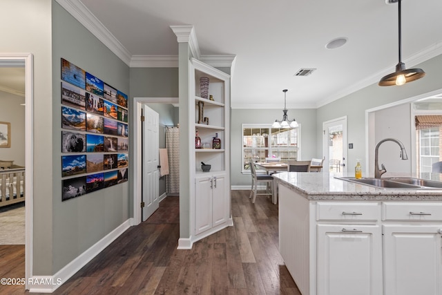 kitchen featuring visible vents, dark wood-style flooring, a sink, white cabinetry, and crown molding