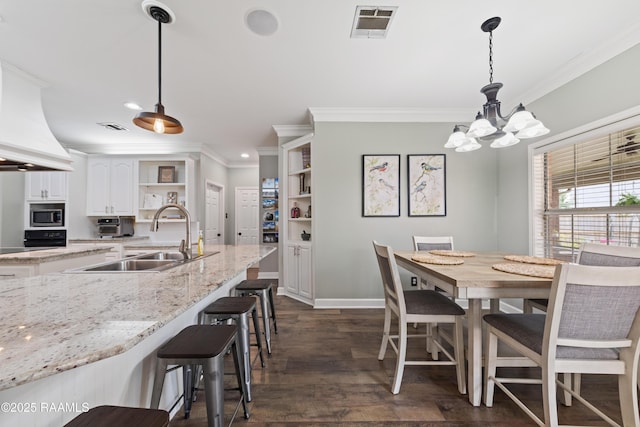 dining space with visible vents, a chandelier, and ornamental molding