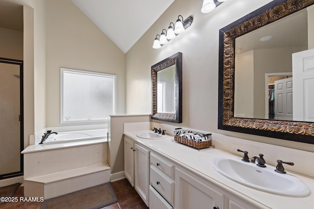 full bath with vaulted ceiling, a bath, double vanity, and a sink