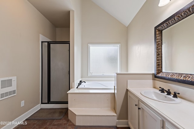 bathroom with a garden tub, heating unit, a shower stall, lofted ceiling, and vanity