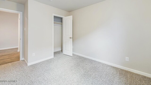 unfurnished bedroom with a closet, baseboards, and carpet