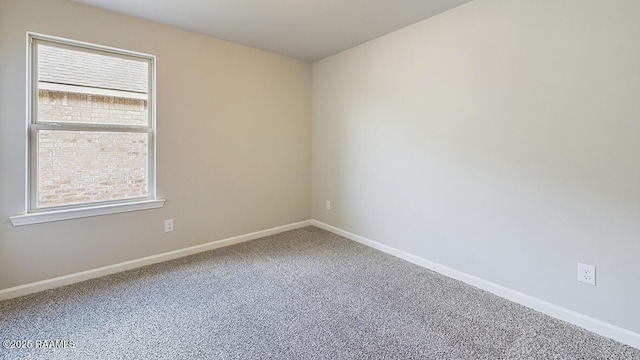 carpeted spare room featuring baseboards