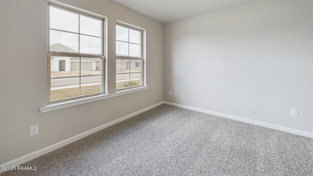 carpeted spare room with baseboards