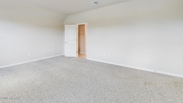 empty room with visible vents, baseboards, carpet, and lofted ceiling